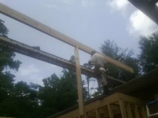 Carpenter setting a ridge beam over a new addition frame — Ice Dam Removal by Roofing Brothers in Dunellen