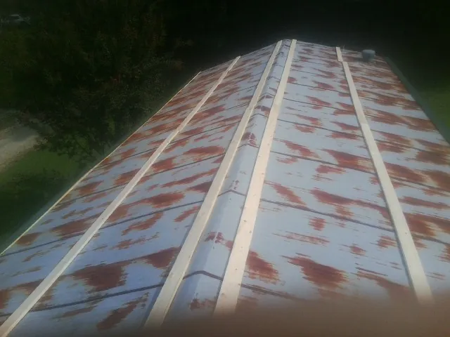 Rusted metal roof panels with new wood purlins before replacement — Storm Damage Roof Repair in Dunellen by Roofing Brothers