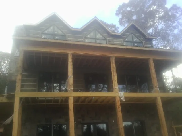 Dormers and porch framing on a large log home under construction — Roof Coating work by our crew in Dunellen