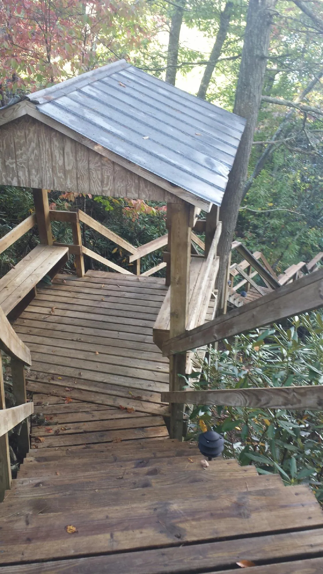 Metal roofed shelter over wooden steps on a wooded walkway — Skylight Repair & Installation work by our crew in Dunellen