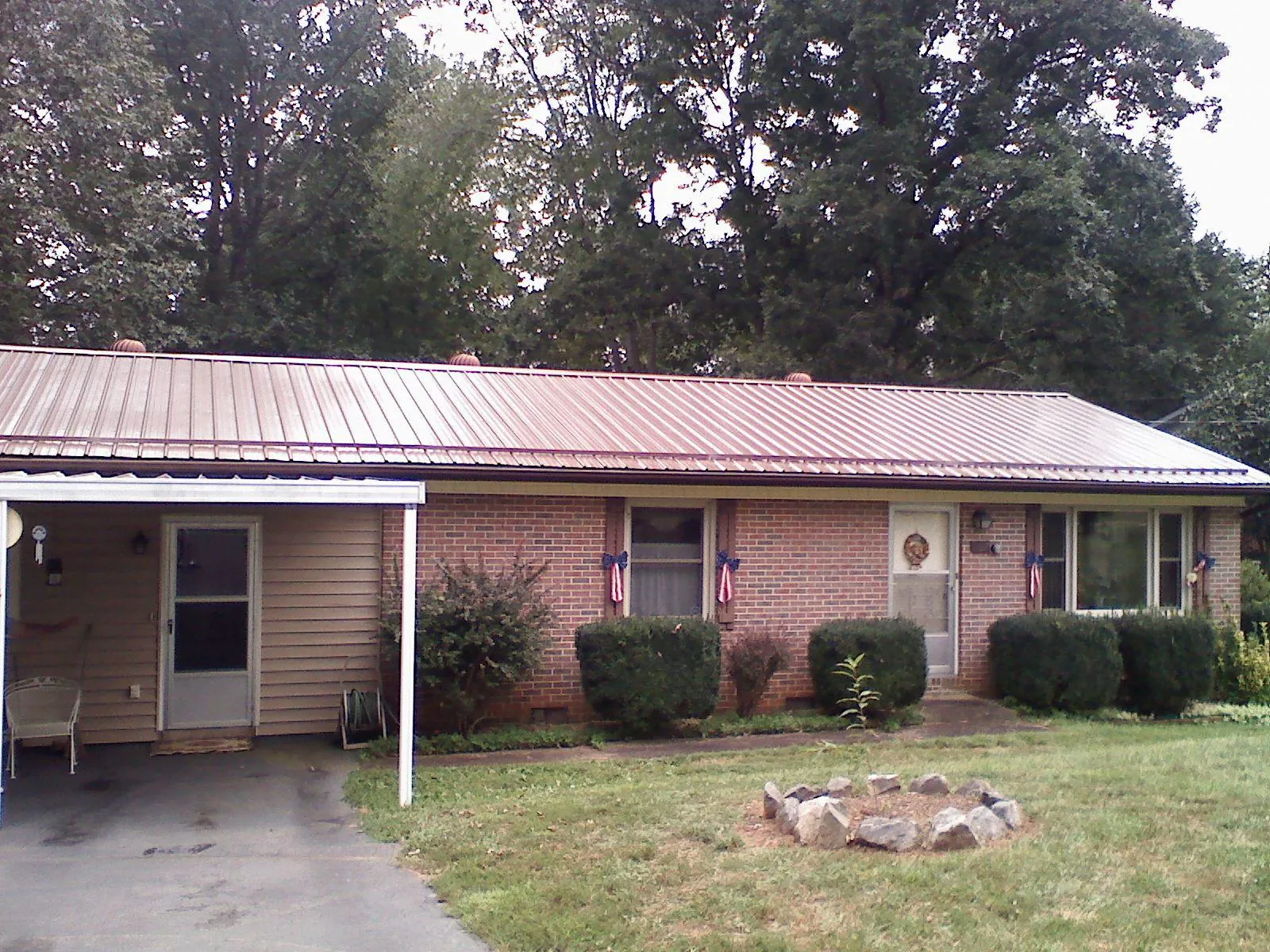 Bronze metal roof and carport on a brick ranch home — Roof Repair work by our crew in Dunellen